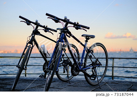 みなとみらいの海沿いをサイクリングし夕焼けの海をバックに記念撮影の写真素材