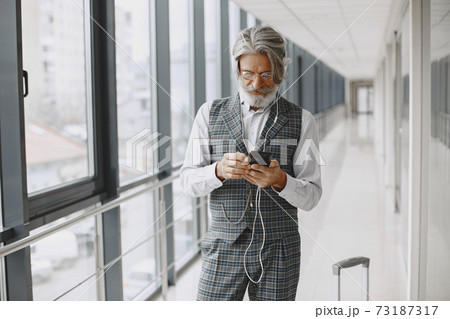 Senior businessman with travel suitcase in airport 73187317