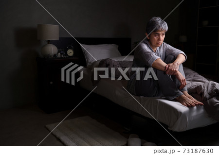 Depressed senior woman sitting in bed cannot sleep from insomnia Depressed senior woman sitting in bed cannot sleep from insomnia 73187630