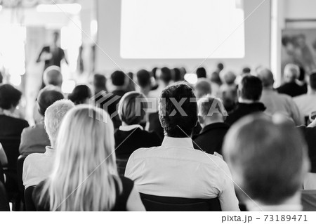 Speaker giving a talk in conference hall at business meeting event. Rear view of unrecognizable people in audience at the conference hall. Speaker giving a talk in conference hall at business meeting event. Rear view of unrecognizable people in audience at the conference hall. 73189471