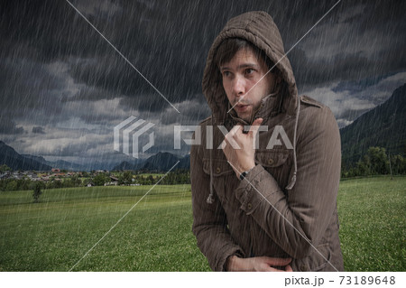 Young man feeling cold during thunderstorm. Young man feeling cold during thunderstorm. 73189648