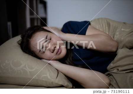 Young asian woman cannot sleep insomnia late at night. Can't sleep. Sleep apnea or stress. Sleep disorder concept. Young asian woman cannot sleep insomnia late at night. Can't sleep. Sleep apnea or stress. Sleep disorder concept. 73190111