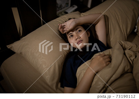 Young asian woman cannot sleep insomnia late at night. Can't sleep. Sleep apnea or stress. Sleep disorder concept. 73190112