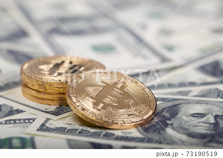 Bitcoins on dollar banknotes background 73190519