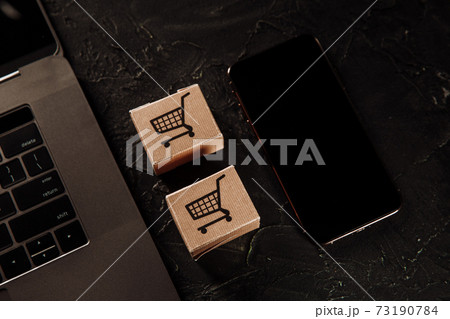Concept of online Shopping. Boxes, laptop and smartphone on a grey background Concept of online Shopping. Boxes, laptop and smartphone on a grey background 73190784