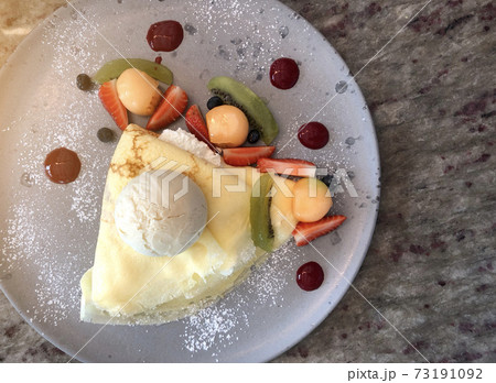 Top view of Tasty crepes with fresh strawberries, raspberries, kiwi, melon and ice cream Top view of Tasty crepes with fresh strawberries, raspberries, kiwi, melon and ice cream 73191092