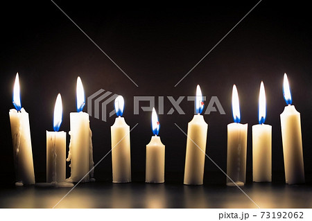 Candles glowing against dark background 73192062