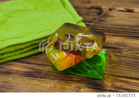 Set of handmade soap bars and towel on wooden background 73192773