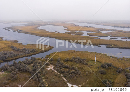 Aerial Shot of the Misty Autumn Floodplains of the Dnieper River with Reed islands in the river Aerial Shot of the Misty Autumn Floodplains of the Dnieper River with Reed islands in the river 73192846