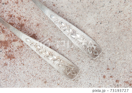 Two old metal spoons on concrete background. 73193727
