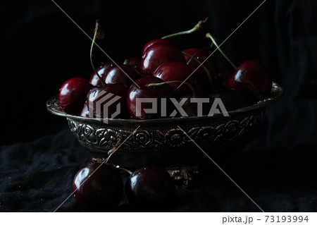 Fresh sweet ripe cherries on rustic plate on black background. Close up. Fresh sweet ripe cherries on rustic plate on black background. Close up. 73193994