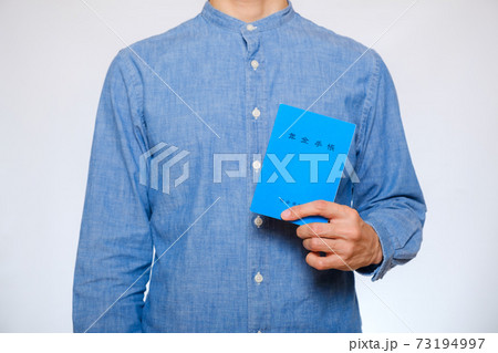 年金手帳を持つ男性 73194997