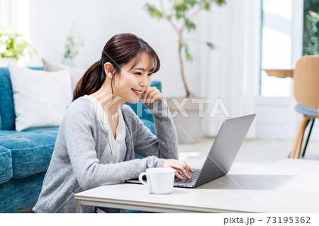 リビングでテレワーク中の若い女性 73195362