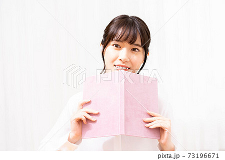 音楽を聴きながら読書をする若い女性 音楽を聴きながら読書をする若い女性 73196671