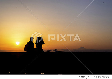夕焼けの東京ゲートブリッジを眺めるカップルのシルエット 夕焼けの東京ゲートブリッジを眺めるカップルのシルエット 73197055