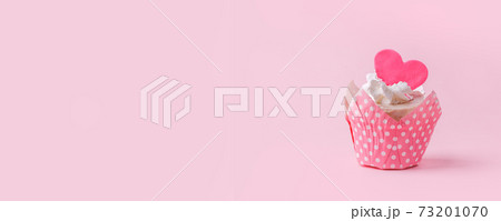 Valentines cupcake with a pink heart shaped cake pick on a pink background, Saint Valentine romance monochrome concept, sweet food, birthday, girl seasonal holiday party, flyer, invitation 73201070