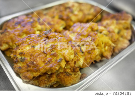 Fried chicken chops in batter are laid out for serving. Close-up of delicious and appetizing food. Fried chicken chops in batter are laid out for serving. Close-up of delicious and appetizing food. 73204285
