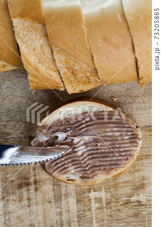 sliced white bread with sweet chocolate butter spread 73205865