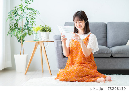 スマホで動画を見る若い女性 73208159
