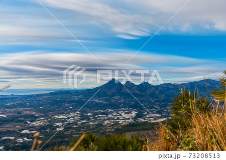 Greenhouses protected under the steep mountains long exposure 73208513