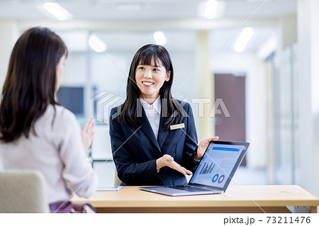 受付にいるスーツの女性に相談するイメージ 73211476