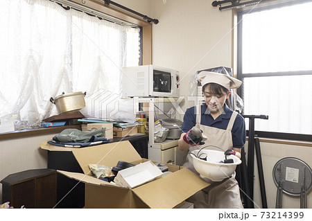 散らかった部屋を片付ける女性作業員 散らかった部屋を片付ける女性作業員 73214399