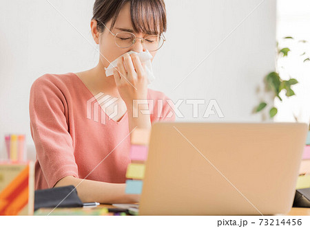 花粉症で鼻水が止まらない若い女性 73214456