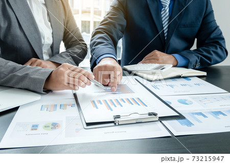 Two business leaders talk about charts, financial graphs showing results are analyzing and calculating planning strategies, business success building processes 73215947