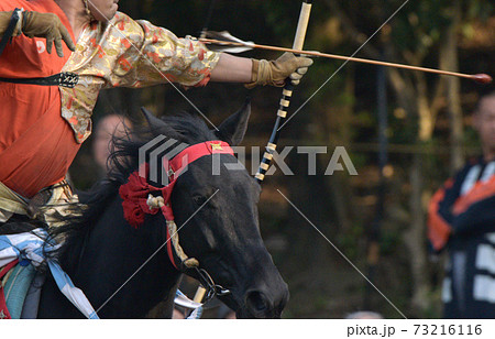 高田馬場流鏑馬で疾走する馬上から的に向かって矢を射る射手 73216116