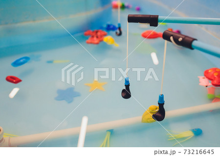 Fishing in the paddling pool. Childrens toys in the pool. Toy fish