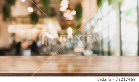 Empty wooden table top with lights bokeh on blur restaurant background 73217468