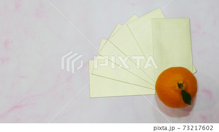 Top view of mandarin orange with a stack of golden ang pow (a monetary gift given during special occasion in Chinese culture, especially Chinese New Year). Top view of mandarin orange with a stack of golden ang pow (a monetary gift given during special occasion in Chinese culture, especially Chinese New Year). 73217602