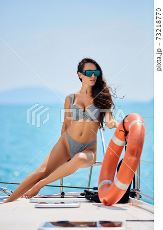 Young happy woman in sexy swimsuit enjoying morning sun at yacht Young happy woman in sexy swimsuit enjoying morning sun at yacht 73218770