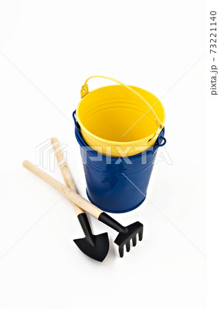garden shovel, rake and blue metal bucket isolated 73221140