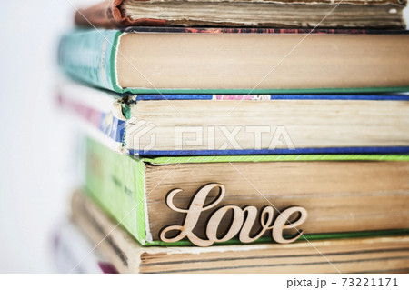 on a stack of old books wooden word love 73221171