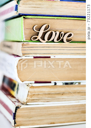 on a stack of old books wooden word love 73221173