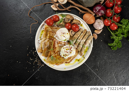 Crepe with grilled chicken sausages, mushrooms, cherry tomatoes and poached egg. A hot continental breakfast. 73221404