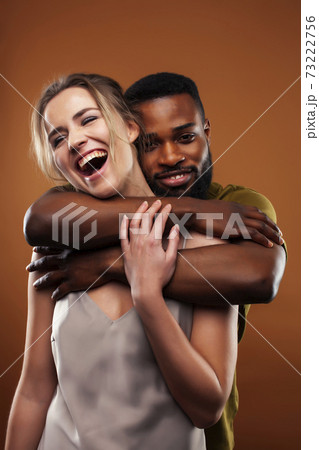 oung pretty couple diverse races together posing sensitive on brown background, lifestyle people concept oung pretty couple diverse races together posing sensitive on brown background, lifestyle people concept 73222756