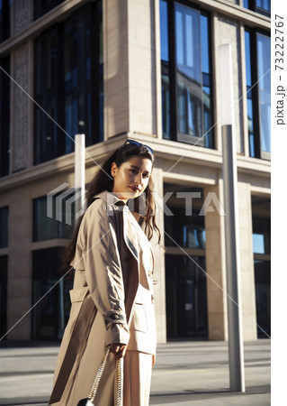 young pretty brunette woman in fashion suit at business building posing cheerful, lifestyle people concept 73222767