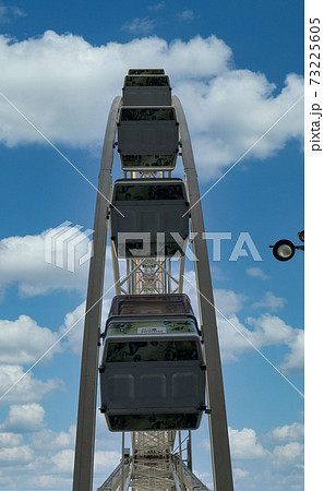 Ferris wheel on blue sky with white fluffy clouds background 73225605