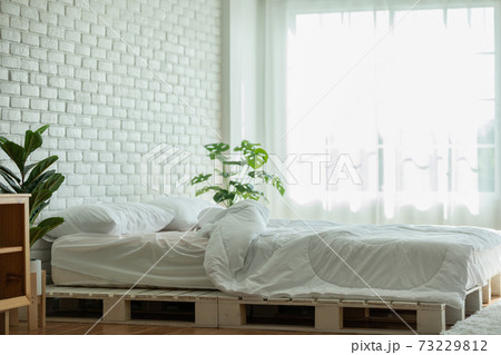 Messed bed with white pillow and blanket with natural light in bedroom in the morning,Messy bed after wake up,Messy bed and Cozy Bedroom Concept 73229812