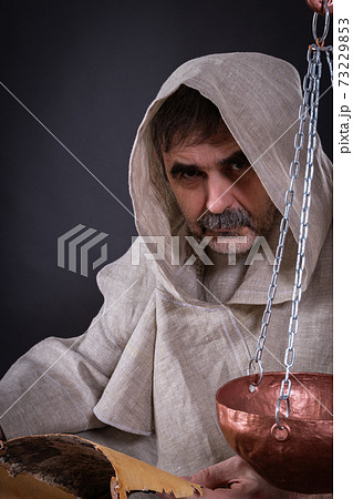 A monk alchemist is engaged in science, writing ancient manuscripts on birch bark A monk alchemist is engaged in science, writing ancient manuscripts on birch bark 73229853
