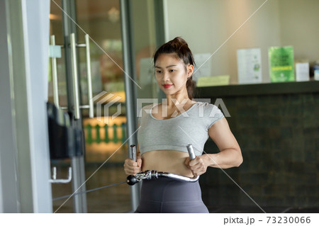 Happy Asian Sporty young woman in sportswear workout and exercise with back cable machine at modern gym,Sport and Recreation Concept Happy Asian Sporty young woman in sportswear workout and exercise with back cable machine at modern gym,Sport and Recreation Concept 73230066