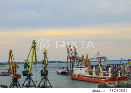 Hoisting cranes and industrial ships at cargo sea port in Odessa, Ukraine Hoisting cranes and industrial ships at cargo sea port in Odessa, Ukraine 73230322