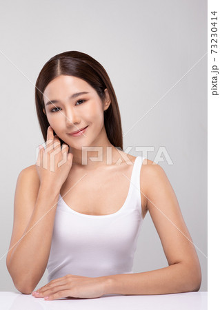 Beautiful Asian young woman touching soft cheek smile with clean and fresh skin Happiness and cheerful with positive emotional,isolated on gray background,Beauty and Cosmetics Concept 73230414