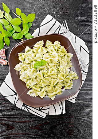 Farfalle with pesto in plate on black board top 73232999