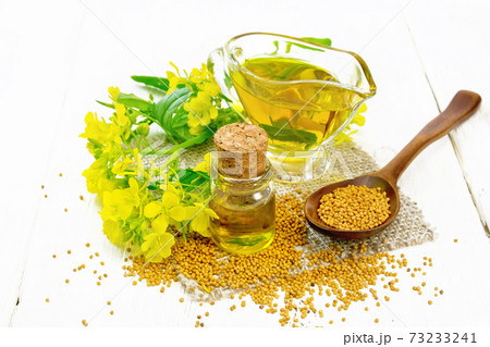 Oil mustard in jars and gravy boat on white board 73233241