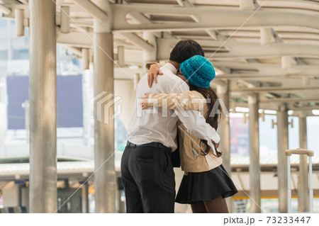 Happy couple hugging in a modern city after arrival. 73233447