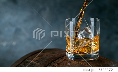 Whiskey Liquid falling into Glass 73233721