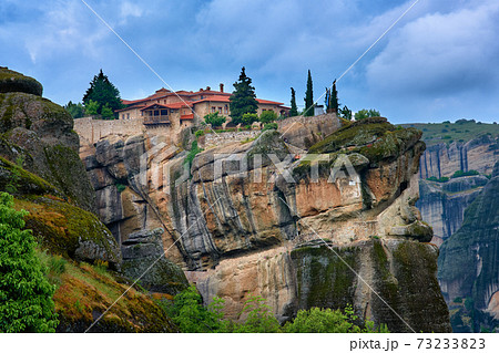 Close view of clifftop Eastern Orthodox monastery of Holy Trinity or Agia Triada in famous Meteora valley, Greece, UNESCO World Heritage, cloudy sky 73233823